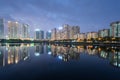 Buildings with reflections on lake at twilight at Thanh Xuan park. Hanoi cityscape at twilight period Royalty Free Stock Photo