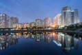 Buildings with reflections on lake at twilight at Thanh Xuan park. Hanoi cityscape at twilight period Royalty Free Stock Photo