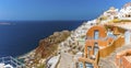 The buildings of the village of Oia, Santorini tumble down the cliffside to the azure blue sea in the caldera