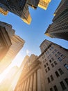 Buildings of Wall Street towering overhead against a blue sky background in the historic financial district of New York City Royalty Free Stock Photo