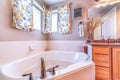 Built in bathtub with stainless steel faucet inside bathroom with floral curtain