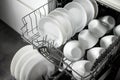 Built-in dishwasher. Clean dishes in the dishwasher. A clean white utensil. Modern technologies in the kitchen. Modern