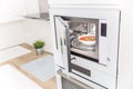 Built-in microwave oven  in the kitchen with tomato soup in white plate Royalty Free Stock Photo