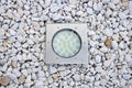 Built-in modern round-shaped lamp on white gravel in the garden Royalty Free Stock Photo