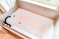 Built in rectangular bathtub with black gooseneck faucet inside home bathroom Royalty Free Stock Photo