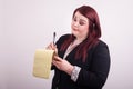 Business woman holding a yellow notepad taking notes looking down at note pad