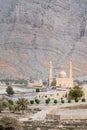 Bukha, Oman - 04.01.2018: Mosque with to minarets and a small fort with ocean in background on a hot sunny day. Travel Royalty Free Stock Photo