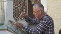 Bukhara master engraves patterns on a tray.