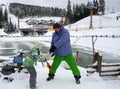 Bukovel, Ukraine - December 26, 2018. Little girls have fun on the snow slides of a frozen mountain lake and enjoy the fresh snow