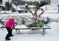 Bukovel, Ukraine - December 26, 2018. Little girls have fun on the snow slides of a frozen mountain lake and enjoy the fresh snow