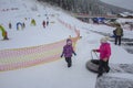 Bukovel, Ukraine - December 26, 2018. Little girls have fun on snow slides, ride inflatable chambers and enjoy the fresh snow on a