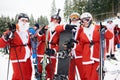 Bukovel, Ukraine - December 09, 2018: skiers and snowboarders in Santa Claus costumes showing V and rock sign on slope