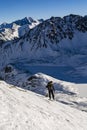 A skier performing a turn while approaching on a snowy slope. Winter tourism - Ski touring. In the background a valley with frozen