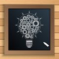 Bulb mechanism with cogs and gears written by chalk on blackboard Royalty Free Stock Photo