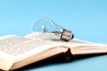 Bulb on an open old book close up Royalty Free Stock Photo