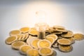 The bulb is placed stack of coins, the bulb is lit in darkness. Image use for finding a way out in the dark Royalty Free Stock Photo