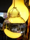 Bulb shaped glass containers filled with water, hanging on a string on display on an urban sidewalk