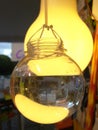 Bulb shaped glass containers filled with water, hanging on a string on display on an urban sidewalk