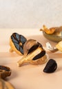Bulbs and cloves of black garlic on a beige table. A conceptual composition of fermented black garlic cloves. Healthy nutrition, Royalty Free Stock Photo