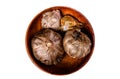 Bulbs and cloves of fermented black garlic in a plate. Isolated, white background. Royalty Free Stock Photo