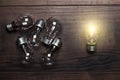 Bulbs uniqueness concept on wooden background Royalty Free Stock Photo