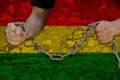 Bulgariamale hands break iron chain, symbol of bondage, protest against background of national flag of bolivia, concept of