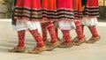 Girls dancing folk dance. People in traditional costumes dance Bulgarian folk dances. Close-up of female legs with traditional