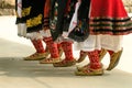 Girls dancing folk dance. People in traditional costumes dance Bulgarian folk dances. Close-up of female legs with traditional