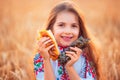 Bulgarian girl, beautiful woman, eating freshly baked banitsa, cheese pie during harvest In golden wheat field Royalty Free Stock Photo