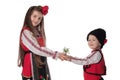 Bulgarian kids boy, girl in folklore costumes, spring flowers, martenitsa symbol of March Baba Marta holiday, Bulgaria