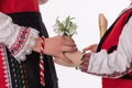 Bulgarian kids boy and girl in traditional ethnic folklore costumes with spring flowers, martenitsa symbol of March Baba Marta