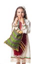 Bulgarian woman  or young girl in traditional folklore dress holds in hands golden wheat and freshly baked homemade bread in a bag Royalty Free Stock Photo