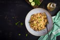 Bulgur pilaf with meat and and vegetables. Delicious healthy warm lunch on black background. Royalty Free Stock Photo