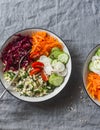 Bulgur, spinach, beets, carrots, cucumbers, tomatoes, daikon - balanced healthy food lunch. On a grey background, top view