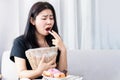 Bulimia nervosa, anorexia nervosa concept with Asian woman put her fingers in her mouth and holding bin in hand try to vomit after