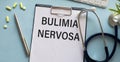 Bulimia nervosa text on notepad on blue background, medical concept Royalty Free Stock Photo