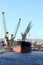 The bulk-carrier LAWIN ARROW loading cement with cranes in the port of Alicante. Royalty Free Stock Photo