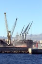 The bulk-carrier LAWIN ARROW loading cement with cranes in the port of Alicante. Royalty Free Stock Photo