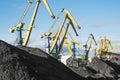 Mountains of coal on the territory of the Murmansk Commercial Sea Port. The unloading of wagons with coal and the loading of this Royalty Free Stock Photo