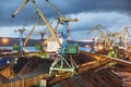 Twilight, Industrial ship, Portal cranes. Loading coal into the holds of a ship at the seaport in Murmansk. Royalty Free Stock Photo