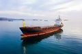 Bulk carrier ship at anchor in orange sunset, aerial view. Colored sky Royalty Free Stock Photo