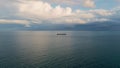 Bulk carrier ship sailing at cloudy day. Aerial view vessel floating dark ocean