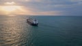 Bulk carrier ship sailing to sunset. Drone view vessel floating in dark ocean. Royalty Free Stock Photo