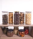 Bulk foods storage in glass jars: dry wild mushrooms, muesli, chocolate, nuts, dates, pistachio, aromatic herbs