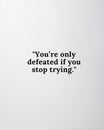 Clean White Background with YouÃ¢â¬â¢re Only Defeated if You Stop Trying Quote for Positive Vibe Wall Decor Royalty Free Stock Photo