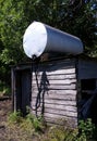 Bulk fuel tank on old sqare log oil shack