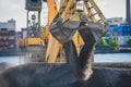 Bulk-handling crane unloading sand, road metal and gravel from cargo vessel ship, heavy vehicle and portal crane loader working Royalty Free Stock Photo