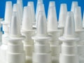 A bulk of nasal spray bottles on blue background Royalty Free Stock Photo