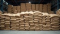 Bulk storage warehouse with stacks of grain filled burlap sacks Royalty Free Stock Photo