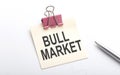 BULL MARKET text on sticker with pen on the white background